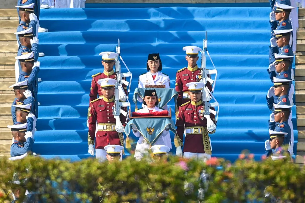 Purna Paskibraka Duta Pancasila 2024, Kirana Ashawidya Baskara (depan) dan Ni Komang Tri Setia (belakang) membawa baki duplikat Bendera Pusaka Merah Putih dan Teks Proklamasi