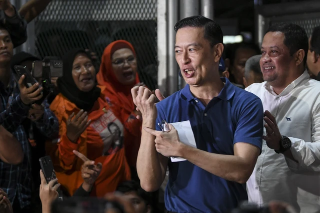 Tom Lembong menunjukan tangannya tidak terikat borgol saat keluar dari Rutan Cipinang