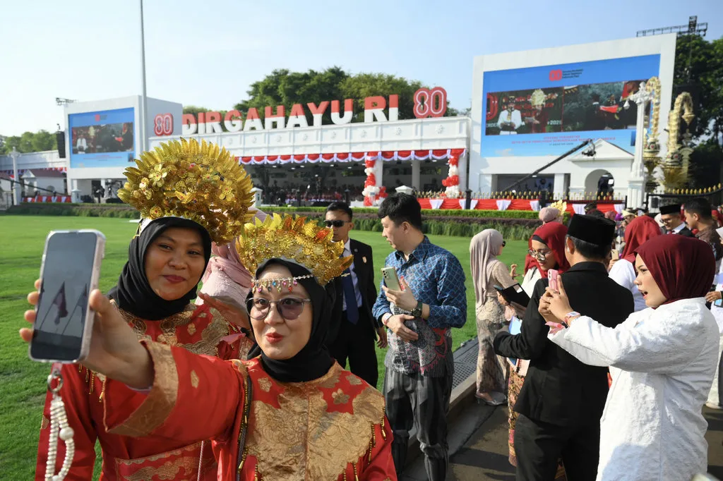 Warga melakukan swafoto saat menghadiri Upacara Peringatan Detik-Detik Proklamasi Kemerdekaan ke-80 Republik Indonesia