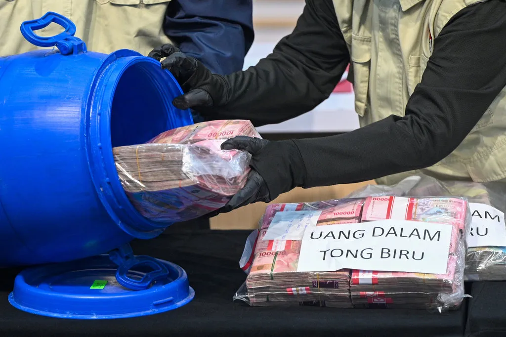 Petugas KPK menunjukkan barang bukti uang